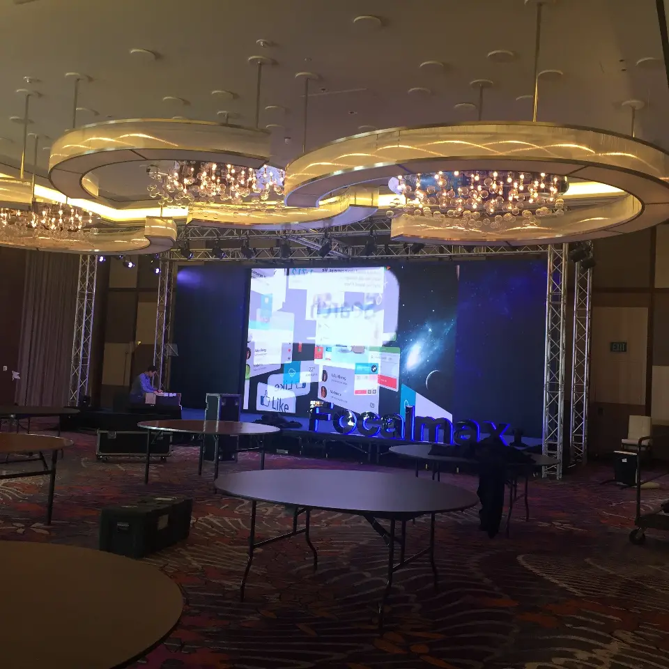 Ballroom stage screen showing imagery while round tables are being set