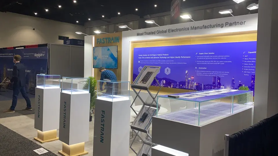 Visitors at FASTRAIN glass showcases with a brochure rack in the aisle