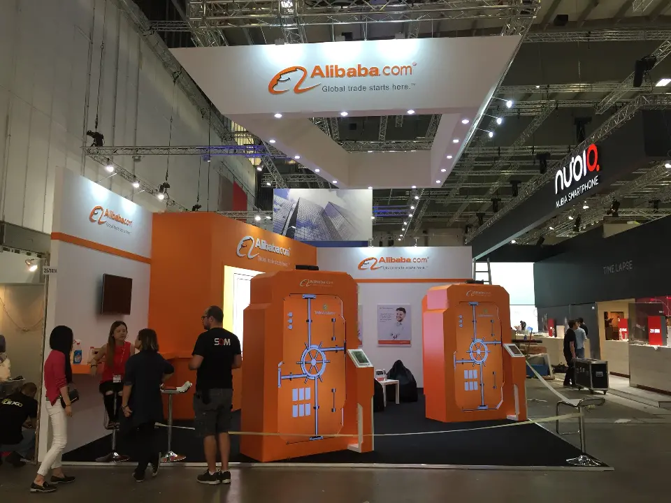 Front view of orange vault-style doors with visitors under the white header