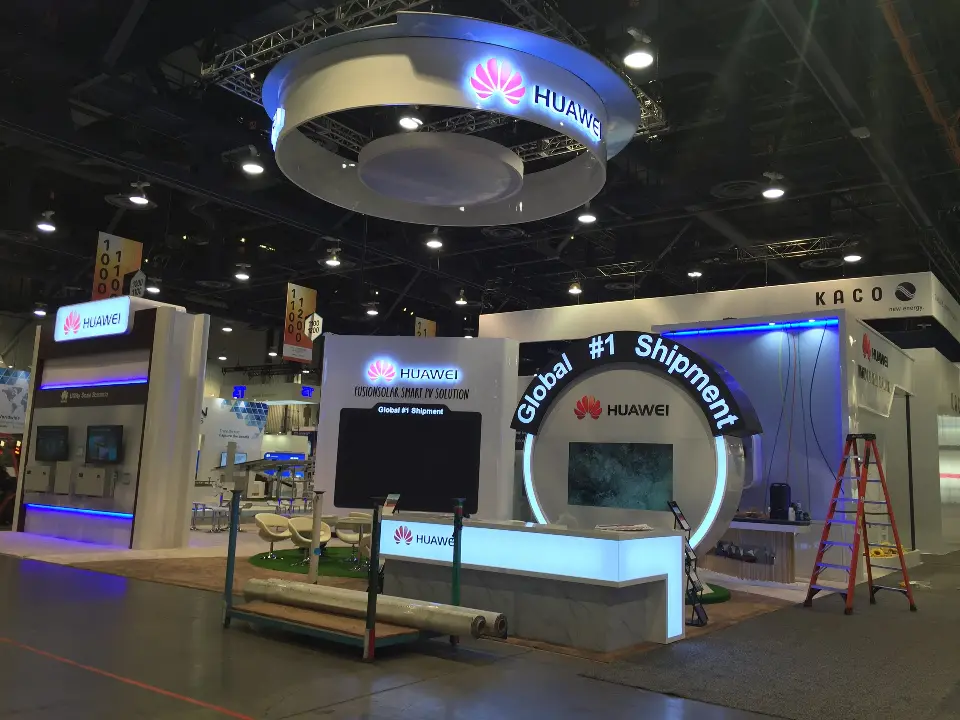 Booth front with the Global #1 Shipment arch, lit counter and planters along the edge