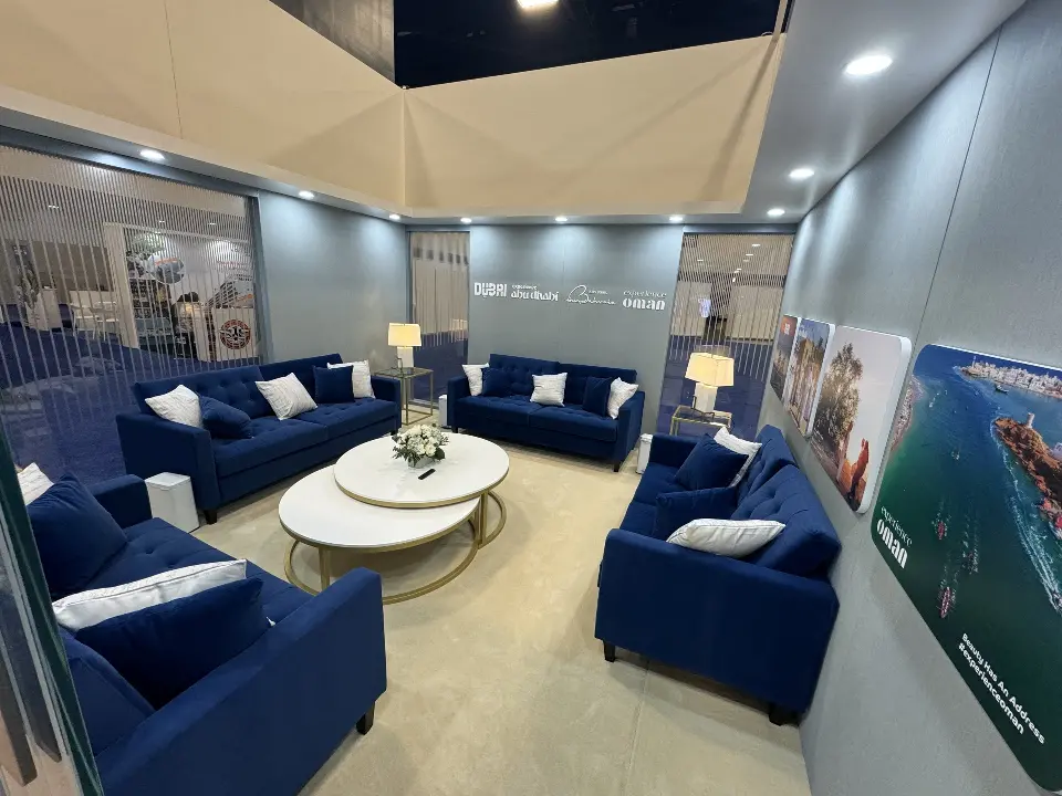 Enclosed lounge with blue sofas, round nested tables and table lamps