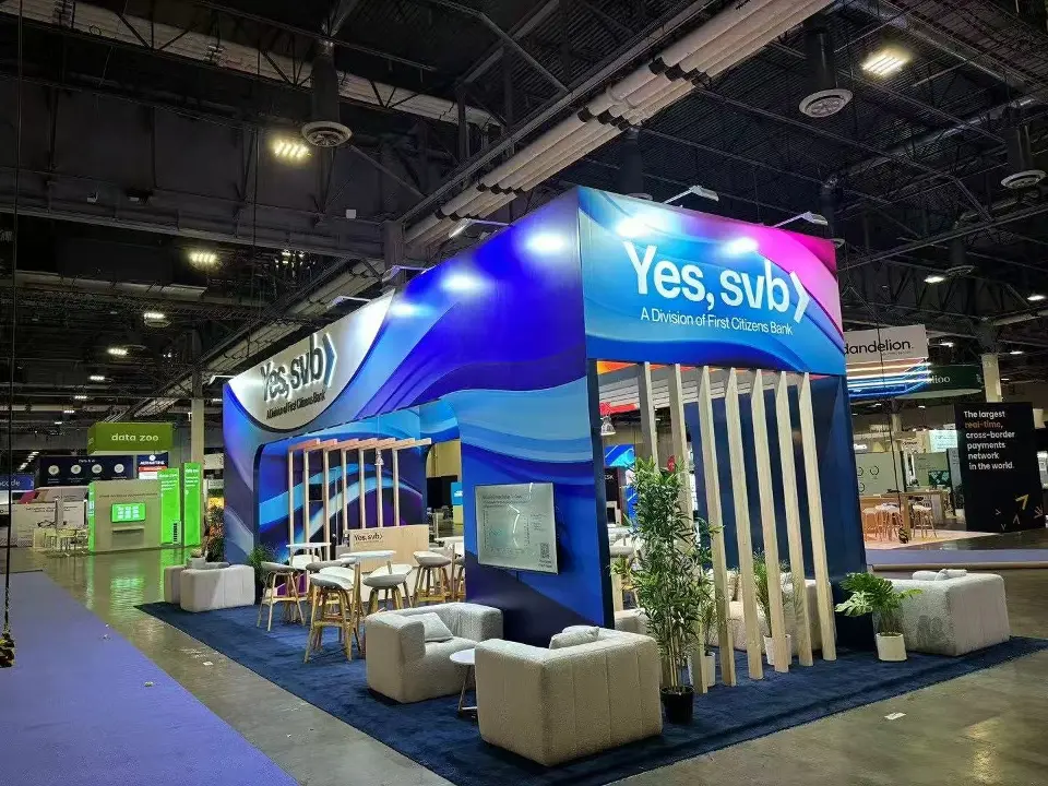 Booth corner with the Yes, svb header, wood-look slat screens and cream lounge armchairs