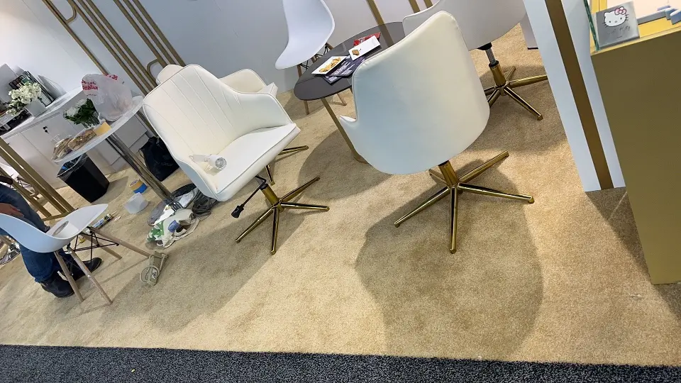 White swivel chairs with gold bases on the pavilion carpet