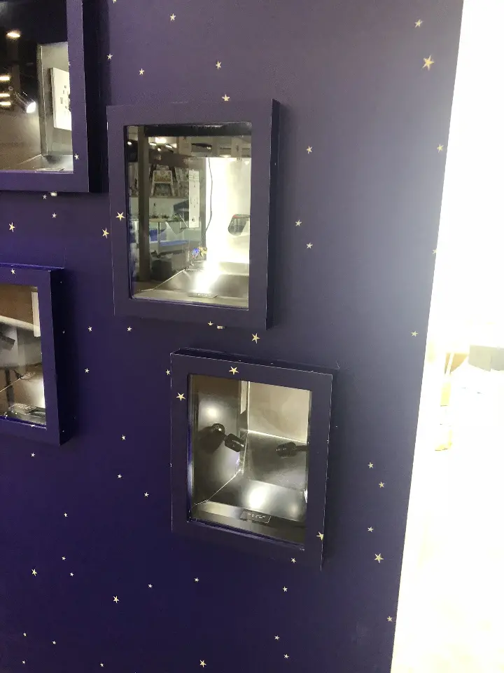 Two lit display niches stacked on the dark starry wall