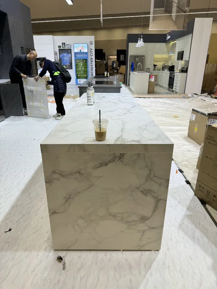 Marble-look kitchen island block in front of the appliance display walls