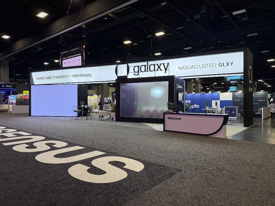 Wide view of the black booth with its header and lettering on the aisle floor