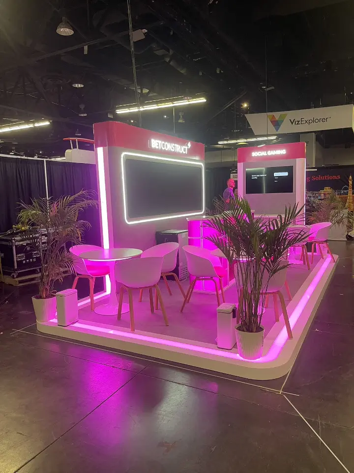 Vertical view of the BetConstruct booth with screen wall and seating