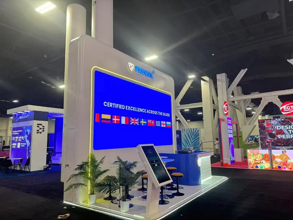 Side view with potted plants, a tablet kiosk and a flags screen