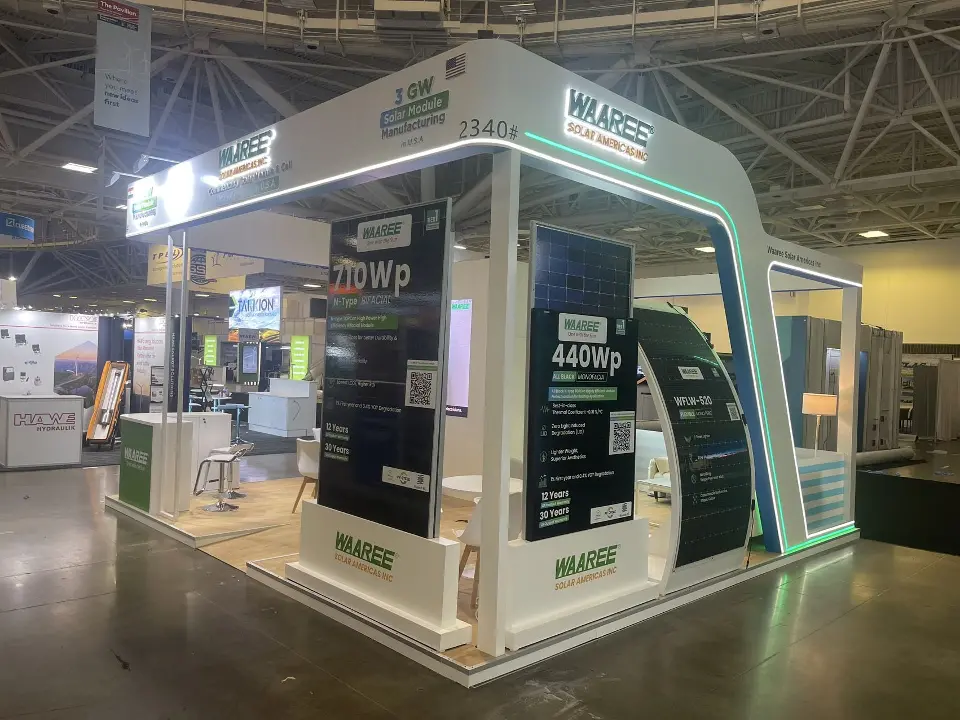 Booth front with 440Wp panel display, curved white wall and lit WAAREE header