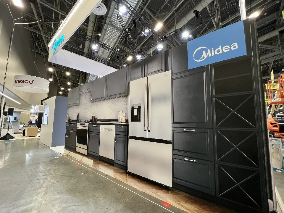 Midea corner tower beside a refrigerator line-up along the aisle