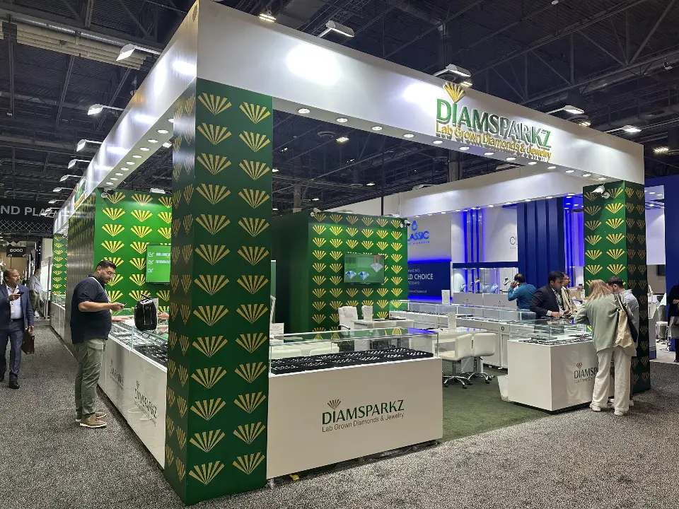 Wide aisle view of the busy booth with visitors at several showcases