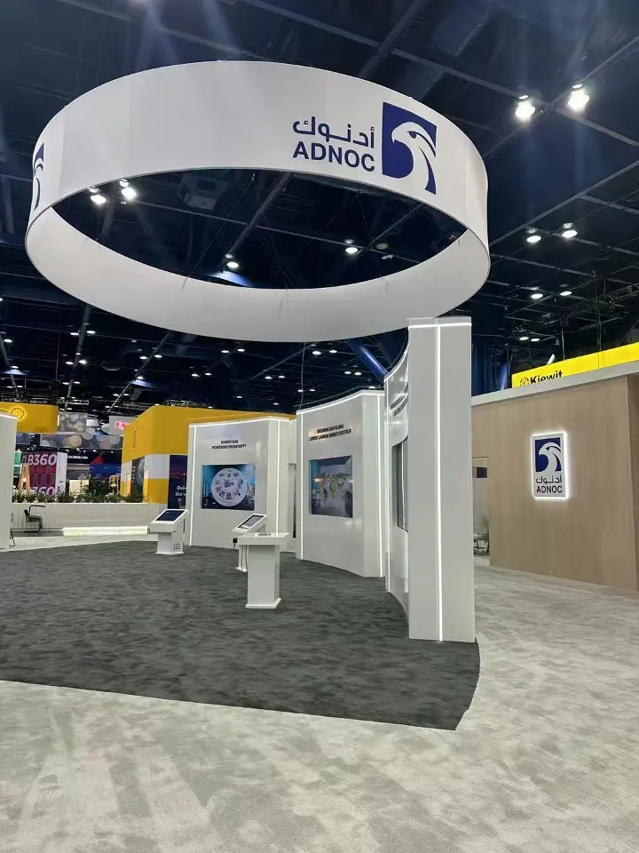 Portrait view of the ADNOC ring sign above white display walls