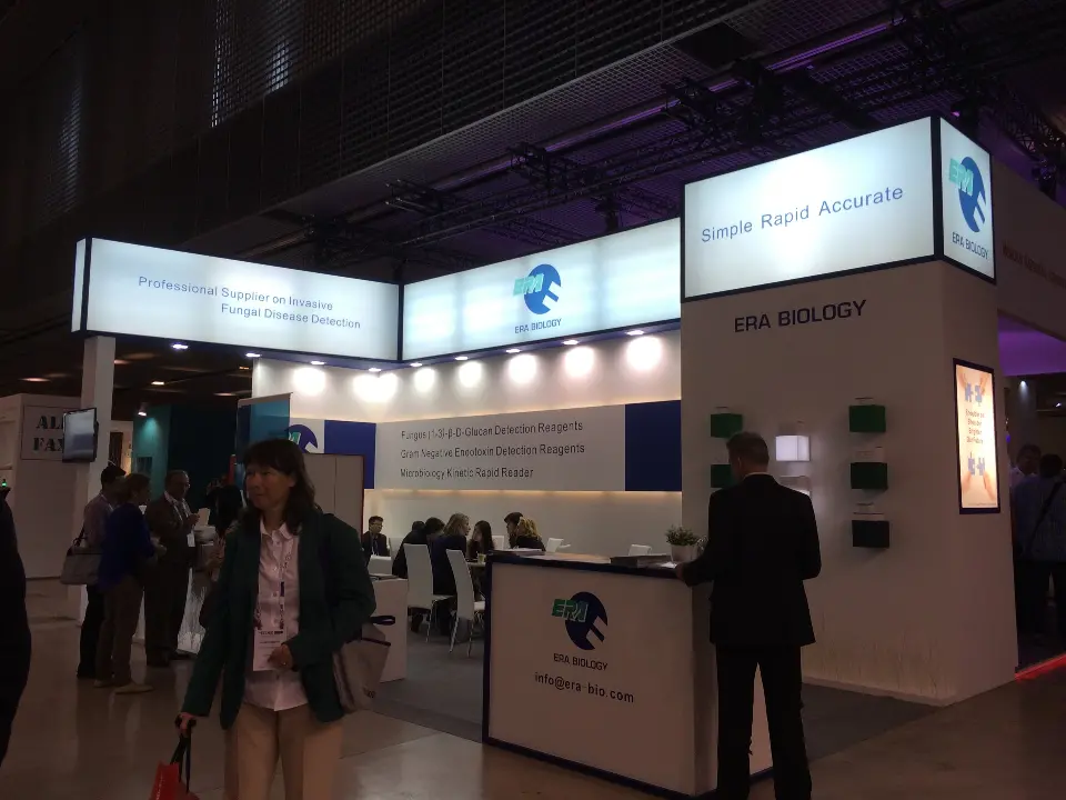 Visitors in front of the booth with lit headers and counter