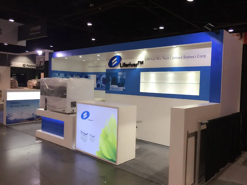 Inline Liferiver booth with blue fascia, lit wall niches, lightbox counter and white sofa