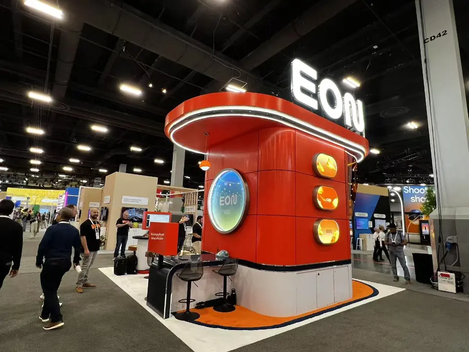 EON booth seen from the aisle with visitors walking past