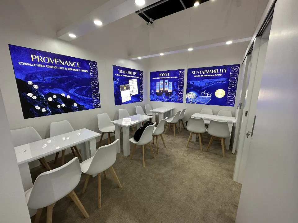 White meeting room with tables, chairs and backlit blue provenance panels