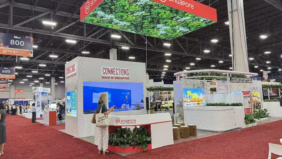 Connections sign and video screen beneath the foliage canopy from the aisle