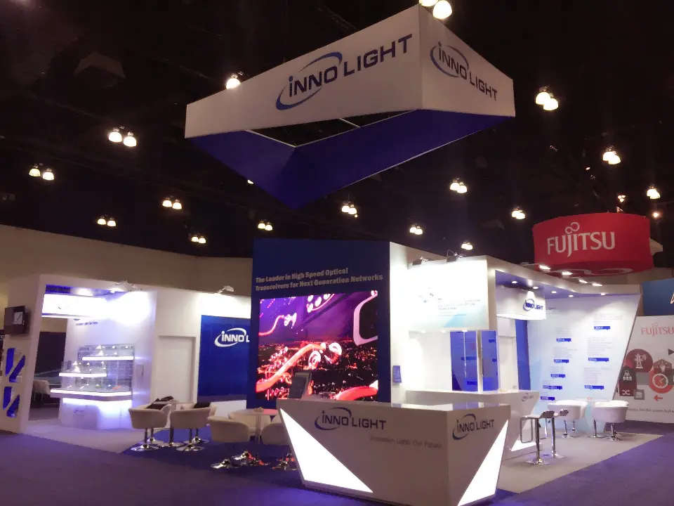 Visitors at the booth with the video screen and lit counter
