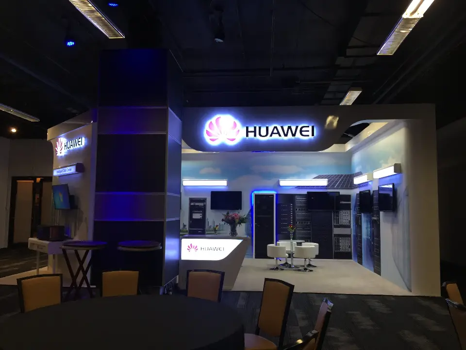 Huawei booth centred on the blue-lit column with screens and server racks behind