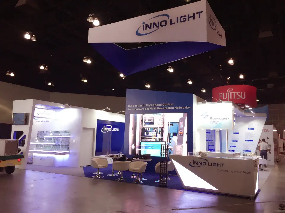 Wide view of the booth with hanging sign, counter and a video screen