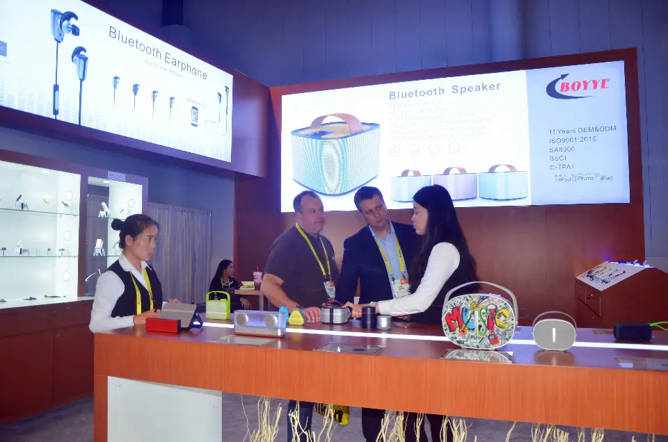 Team and visitors around the counter with speakers set on top