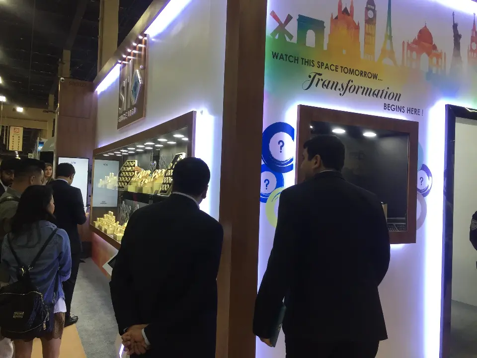 Visitors passing the 'Transformation' skyline graphic and wall screen