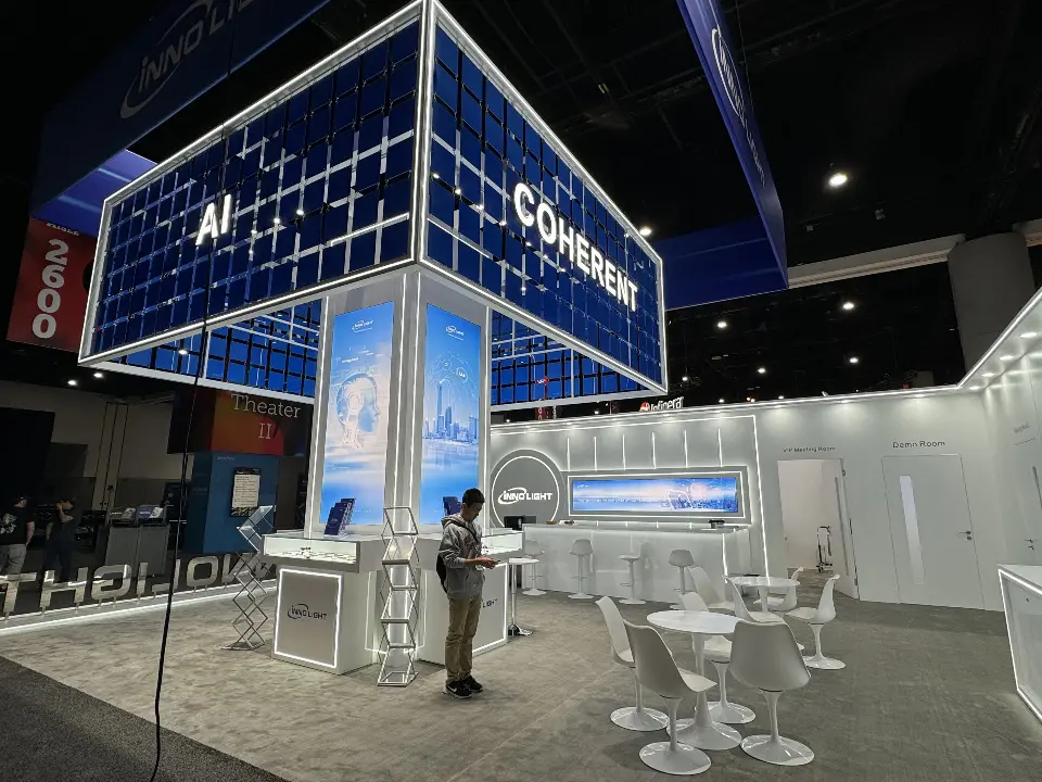 AI and COHERENT faces of the grid tower above showcases and white seating