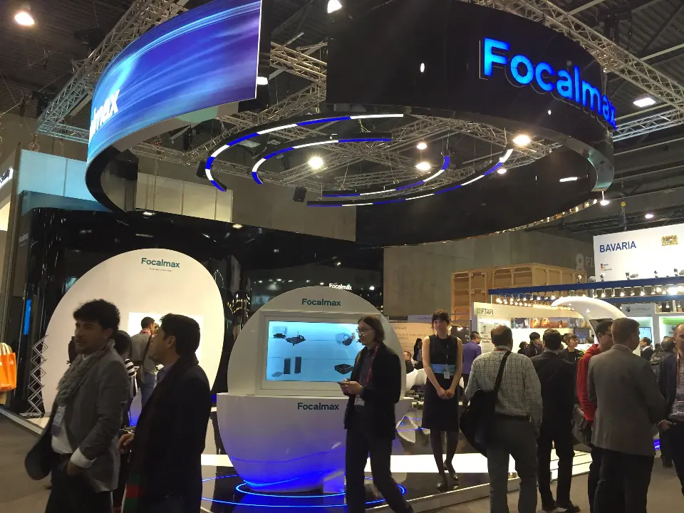 Low angle of the blue-lit Focalmax header above a group of visitors