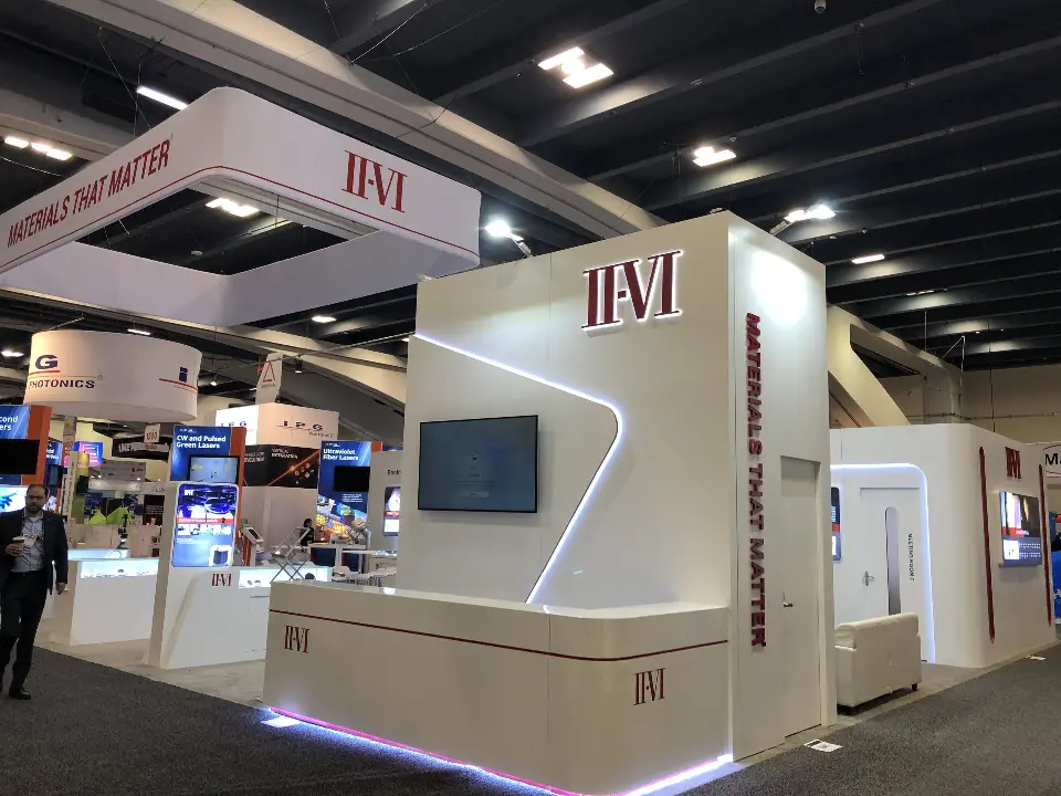 Tall branded tower with a curved light line and wall screen at the corner