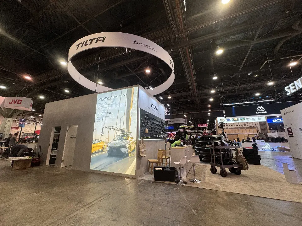 Grey cube wall with backlit panel and lit TILTA logo under the ring sign