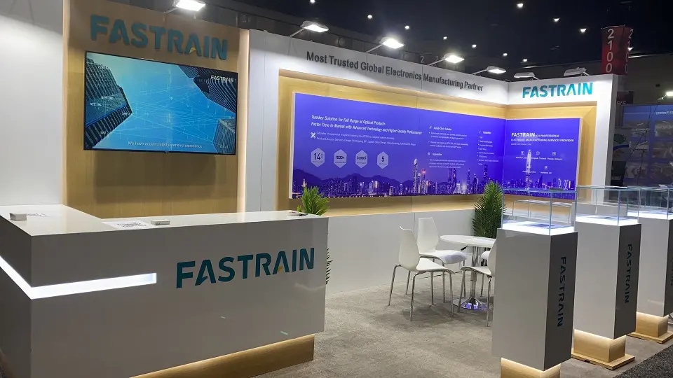 Fastrain stand at OFC 2022 with grey reception counter, white light strip and purple skyline graphic wall