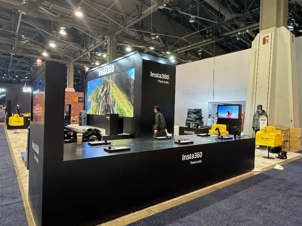 Wide black wall with a video screen above a long counter