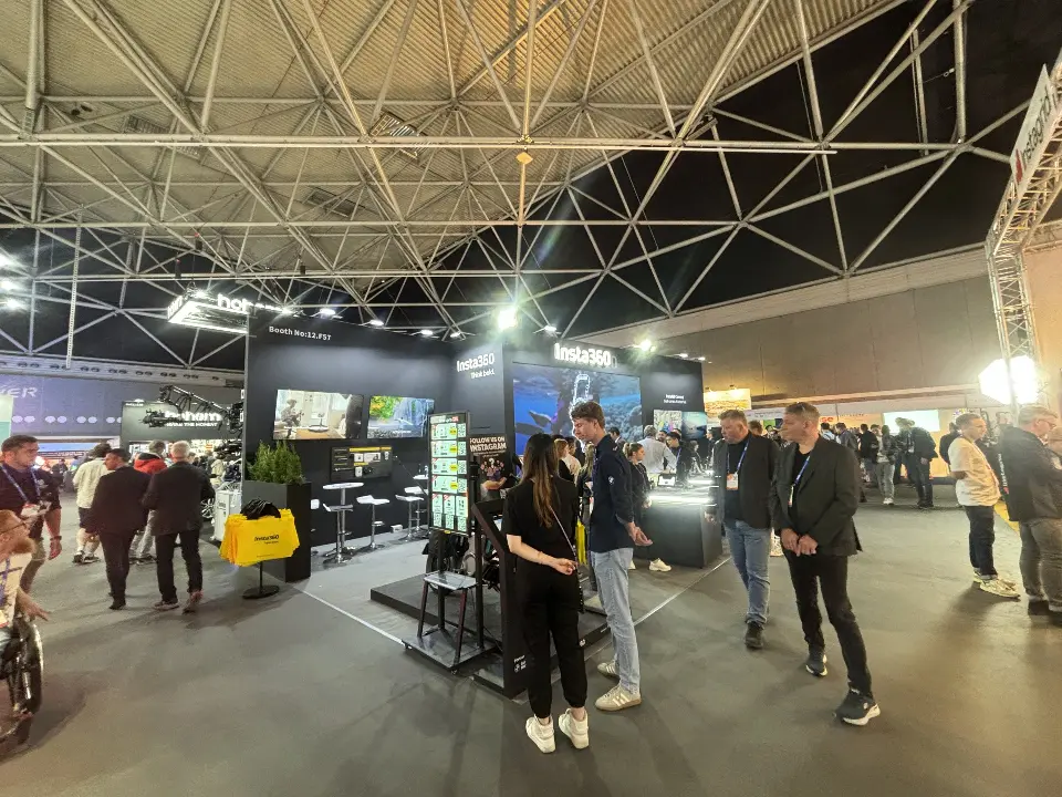 Wide view of the black booth with crowds around the white-edged counters