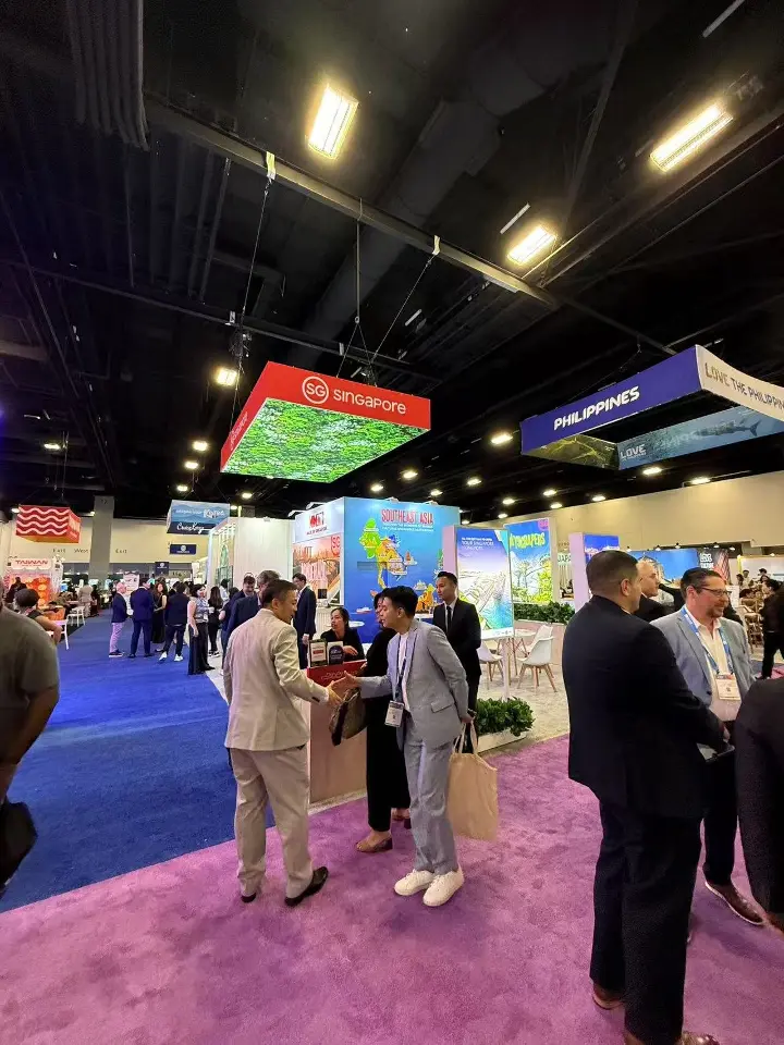 Visitors gathering at the Singapore stand under the red foliage canopy