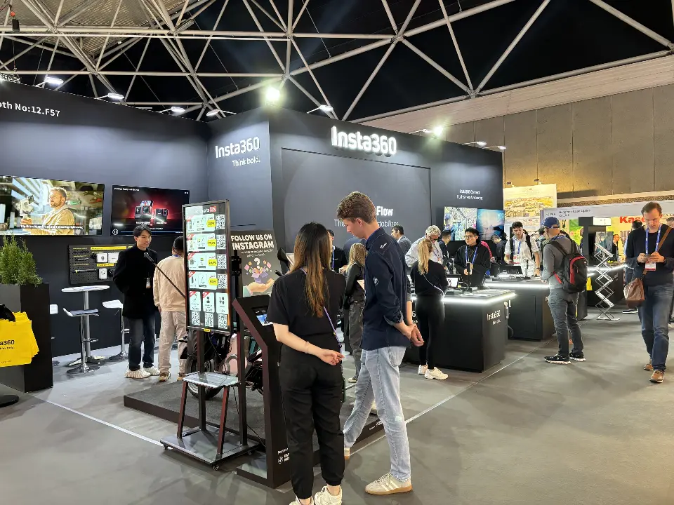 Visitors at lit product counters in front of a camera accessory wall
