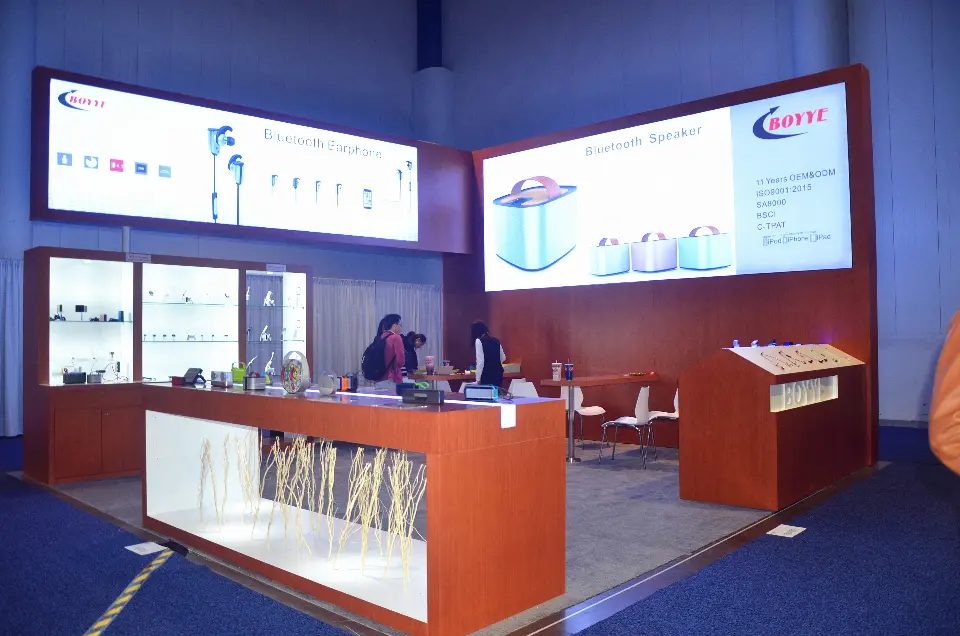 BOYYE booth corner with backlit Bluetooth Earphone and Bluetooth Speaker lightboxes over wood-grain walls