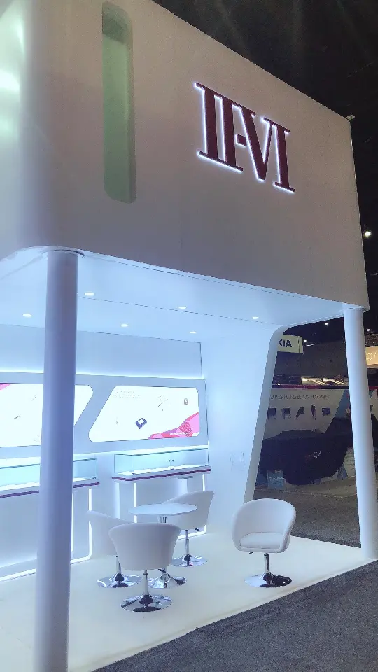 Narrow view of a white wall with II-VI logo and lit display niche