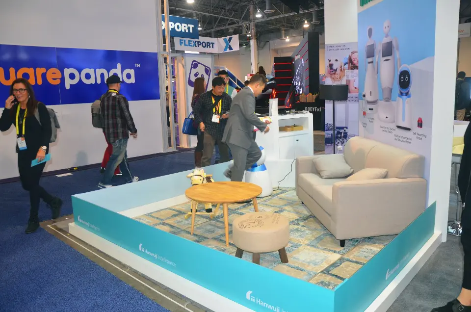 Kids lounge with sofa, round tables and teal floor trim beside the aisle