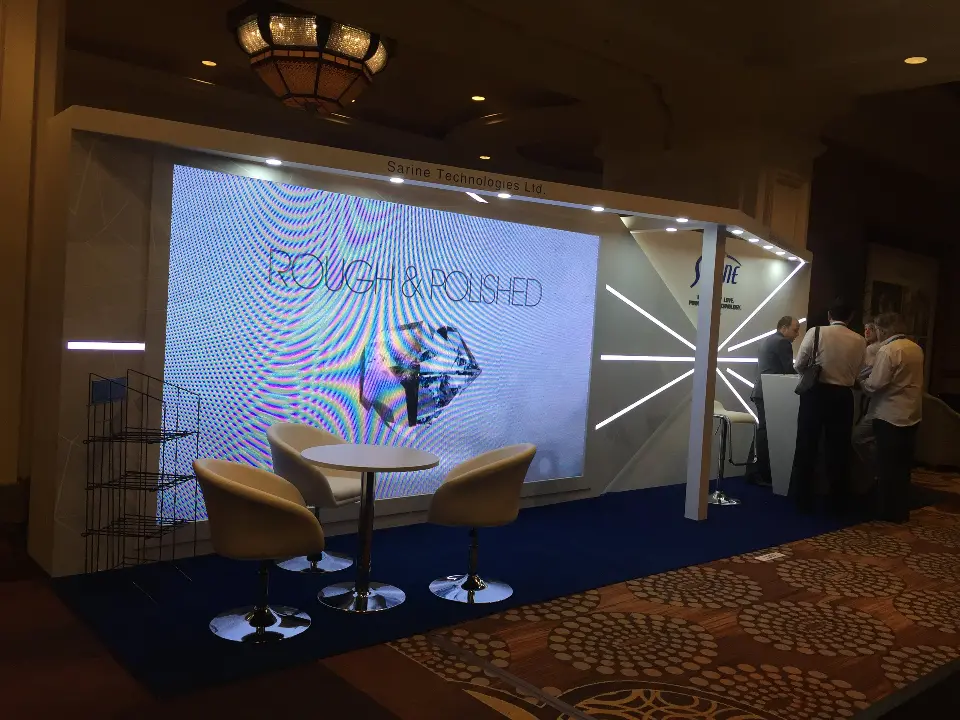 Large video screen with Rough and Polished diamond graphic beside lounge seating