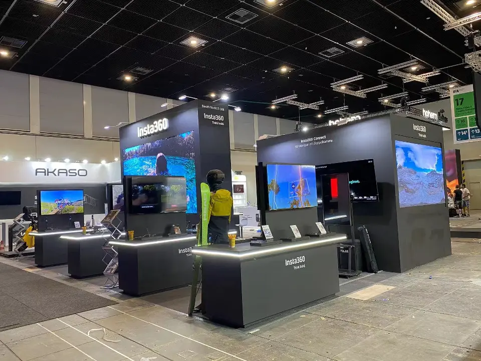 Wide view of black counters, tall screens and product displays along the aisle
