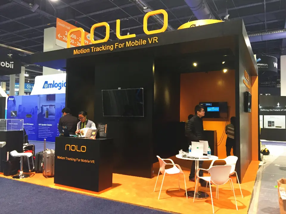 Front of the NOLO booth with white chairs and table near the counter