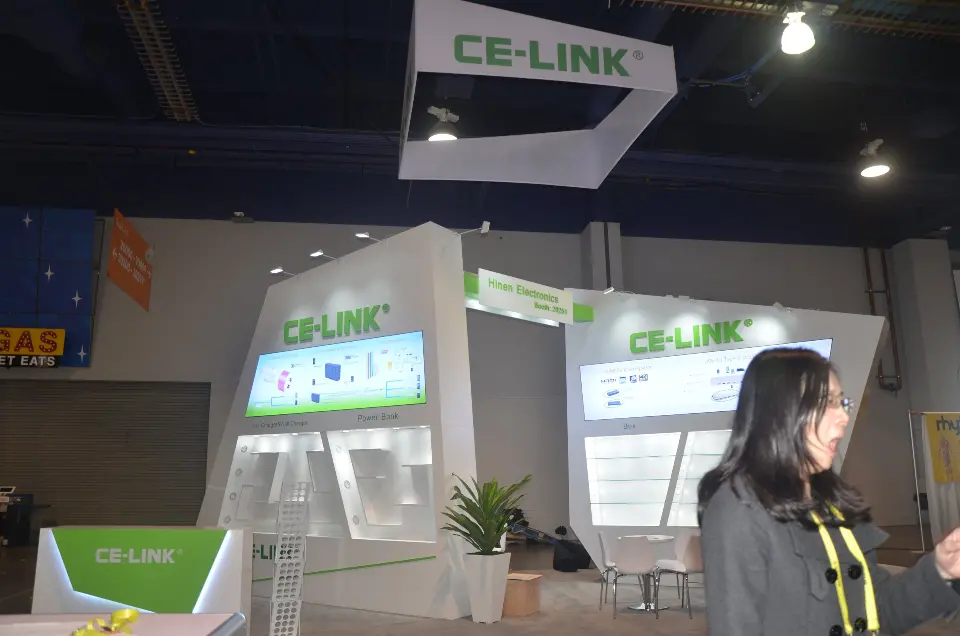 Front of the booth with backlit shelving and a visitor at right