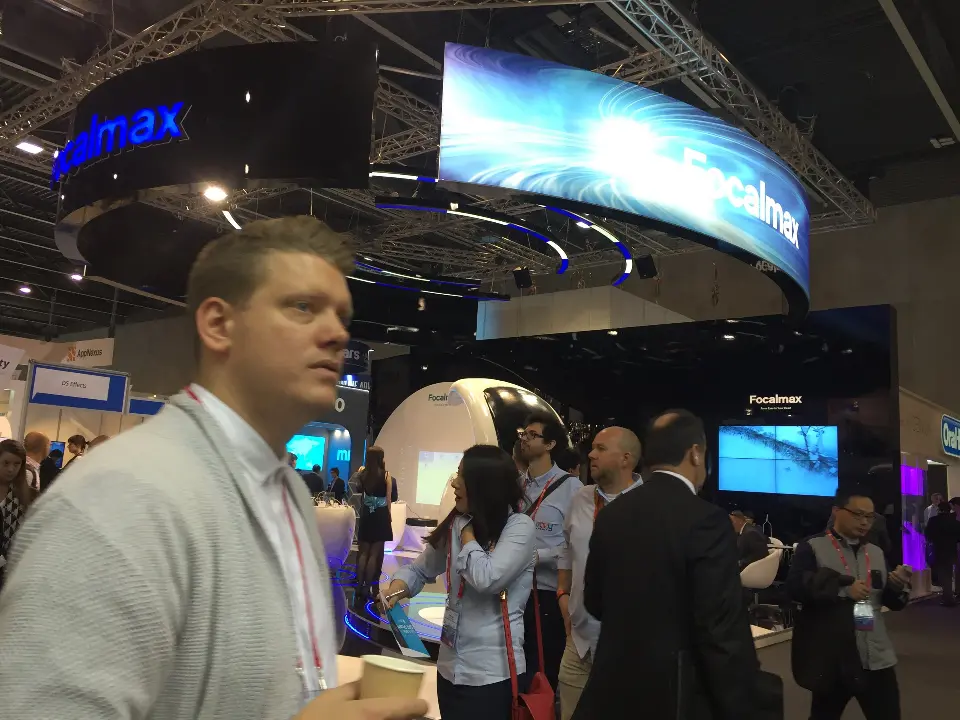 Visitor in the foreground with the white pods and screen kiosks behind him