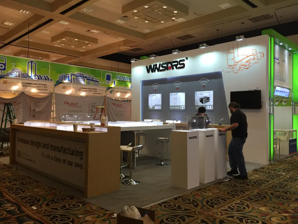Angled view of WNSTARS counters, white logo plinths with clear covers and wall screen
