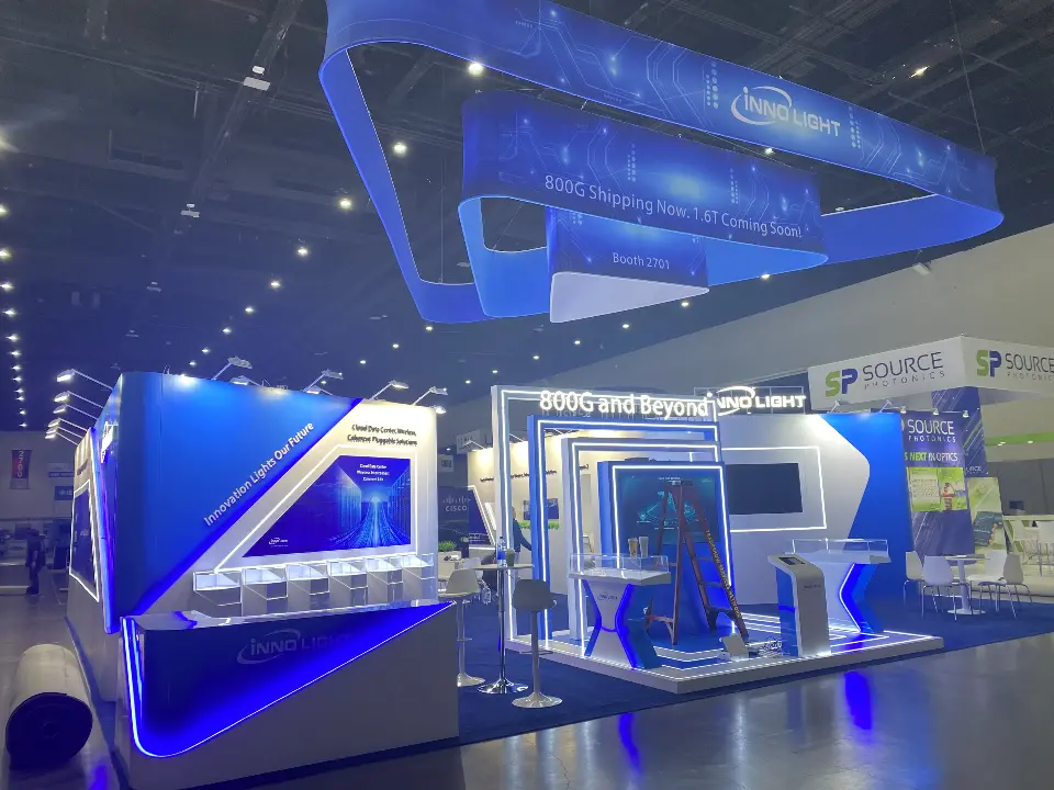 Side view of the InnoLight booth showing the triangular frame and lit graphic walls