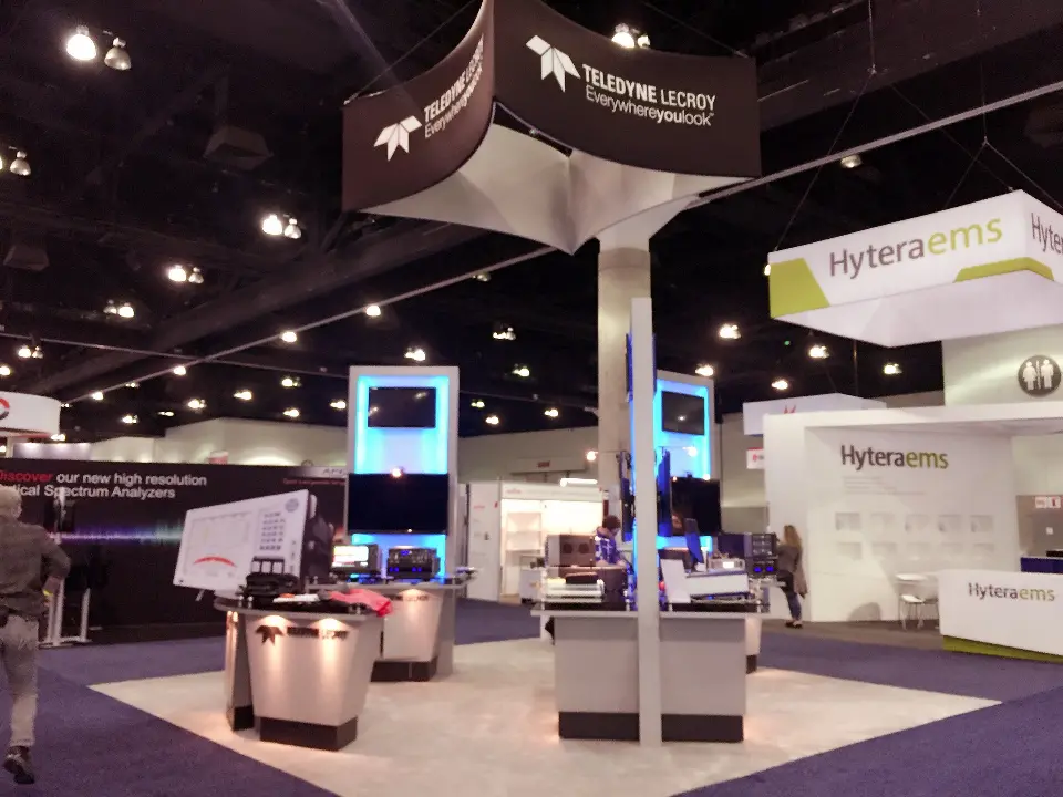 Hyteraems booth in the background behind a neighbouring stand, with white walls and green-accent sign