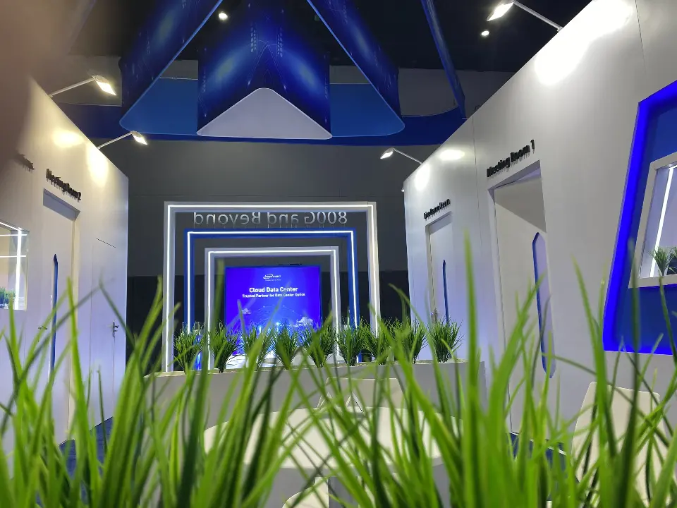 Ground-level view through grasses toward the portal and blue hanging frame