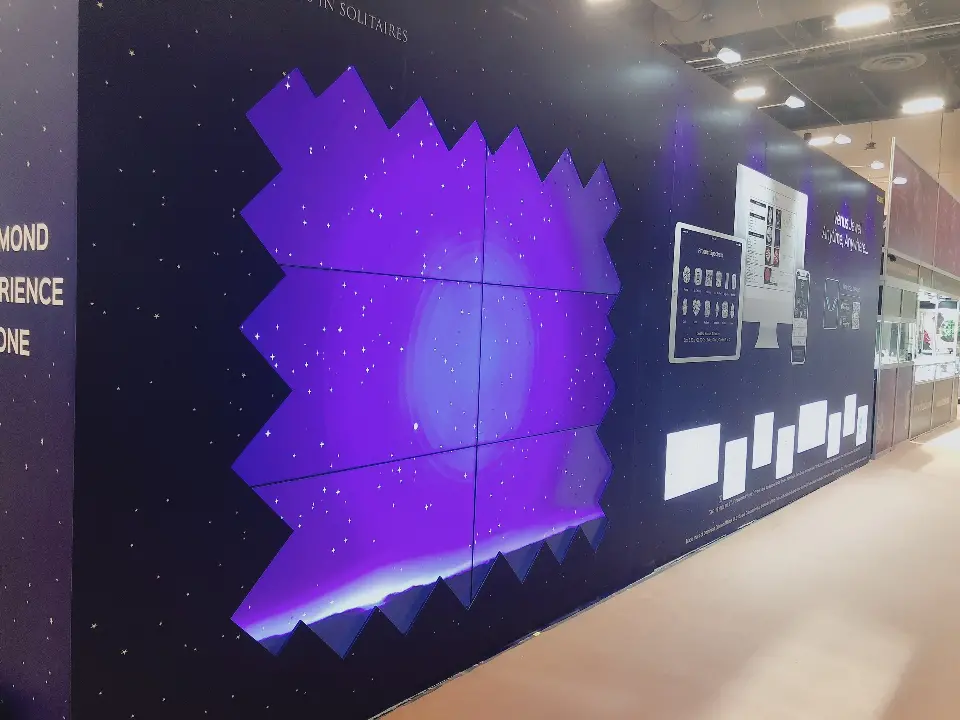 Purple backlit feature wall with a jagged diamond pattern and small frames
