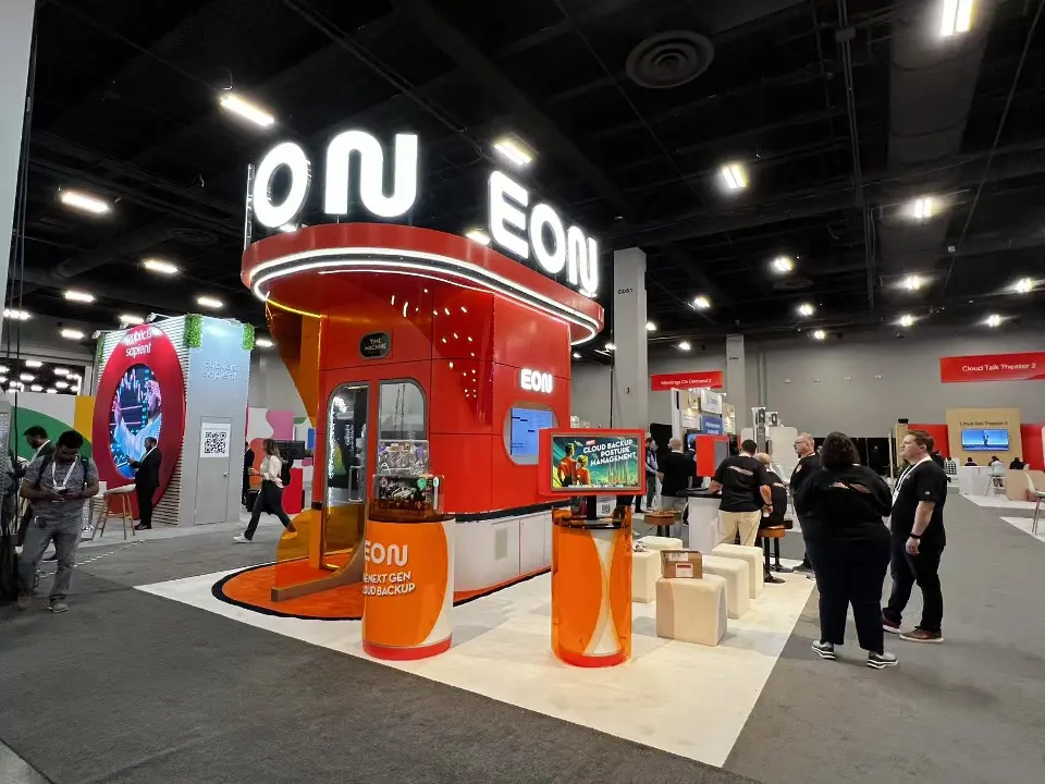 Side view of the EON kiosk at Google Cloud Next 2025 with orange counters and seating cubes