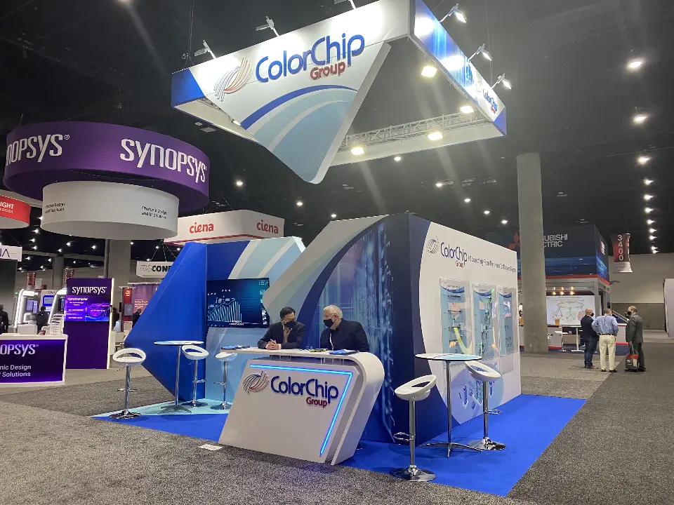 Finished ColorChip booth with rounded logo counter, white stools and curved wall graphics